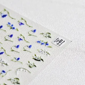 Adesivi per unghie con mughetto bianco e motivi floreali blu per decorazioni eleganti