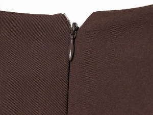 Detailed view of invisible zipper closure on stylish pleated brown short dress fabric