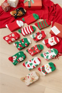 Flat lay of colorful Christmas coral fleece socks on wood floor with festive gift decor