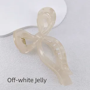 Close-up of a jelly cream bow-shaped hair claw clip with smooth resin texture and gold spring