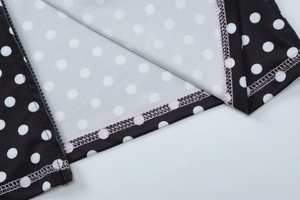 Detailansicht von Polka-Dot-Stoff mit rosa Ziernähten und seitlichem Reißverschluss