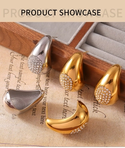 Gros plan de boucles d'oreilles gouttes d'eau or et argent avec zircons sur fond vintage