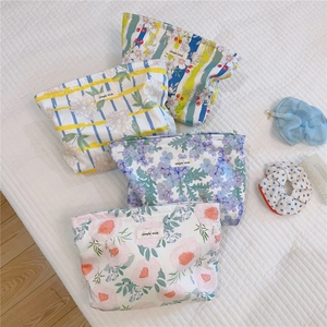Macro detail of quilted cotton makeup bags with floral patterns and zipper closure