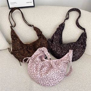 Detail of leopard print crescent bags with side drawstrings and adjustable straps
