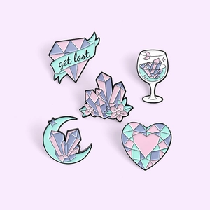 Macro shot of a five-piece enamel pin set featuring colorful crystals and gemstones