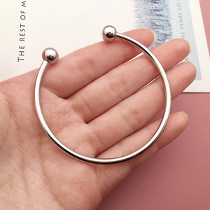 Close-up of minimalist silver adjustable open bangle featuring sleek double bead terminals