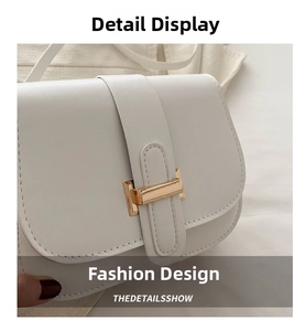 Detail shot of white PU leather crossbody bag featuring a gold H-shaped buckle and stitching