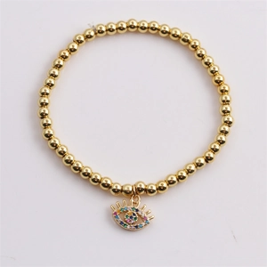 Detail of gold beaded bracelet featuring a colorful zircon inlaid evil eye charm
