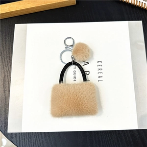 Detail van pluche handtas sleutelhanger in kaki imitatiebont met lederen handvat