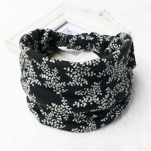Close-up of black floral print elastic wide headband on white faux fur background