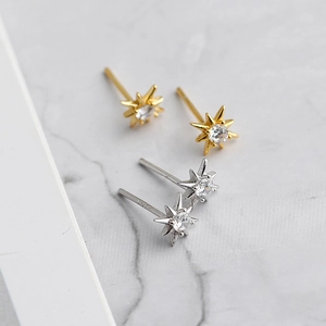 Detail view of gold and silver S925 sterling silver star stud earrings with zircon stones