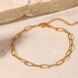 Minimalist gold paperclip chain anklet with adjustable lobster clasp on marble background