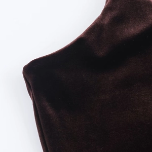Macro shot of dark brown velvet dress fabric showing luxury texture and soft sheen