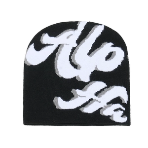 Close-up of black knit beanie featuring graffiti style jacquard patterns and texture