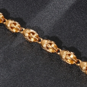 Close-up of golden punk skull necklace featuring detailed metal craftsmanship on black background