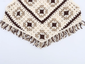 Detail of vintage crochet knit vest with floral patterns and boho fringe tassel edge