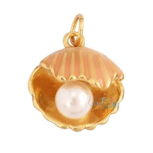 Gros plan d'un pendentif coquillage doré ouvert avec perle blanche et texture striée