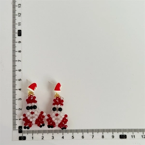 Detailed size measurement of handmade beaded Santa Claus earrings with a ruler reference