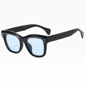 Detail of black rectangular sunglasses frame with blue lenses and silver rivets