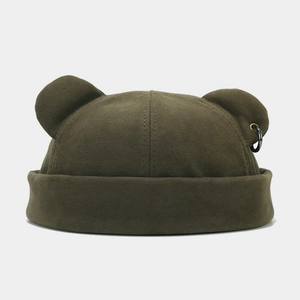 Texture détaillée du bonnet docker vert avec oreilles d'ours et un anneau en métal noir