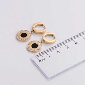 Detail shot of 18k gold plated roman numeral earring with crystals and ruler for size