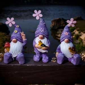 Three gnome garden statues with purple hats and flowers on a dark wood fence