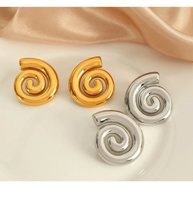 Vue macro des boucles d'oreilles spirales plaquées or 18 carats et argent sur soie