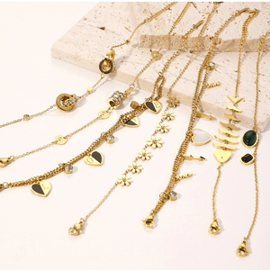 Detail of assorted gold plated jewelry with heart pendants and zircon on stone plate
