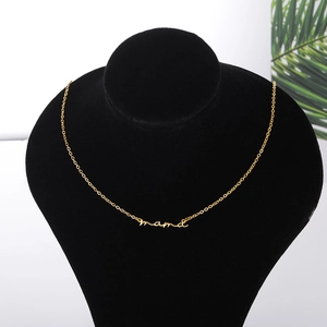 Detailed view of a gold 'mama' letter pendant necklace worn on a mannequin neck