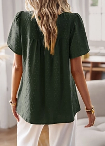 Detail of dark green short sleeve top featuring textured dot fabric and back view design
