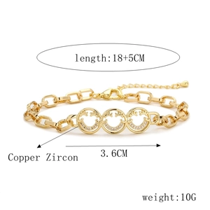 Detail view of gold smiley face bracelet with zircon charms and size specifications
