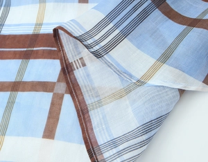 Close-up of lightweight ramie shirt dress fabric with blue and brown plaid pattern