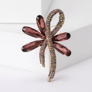 Close-up of elegant dragonfly brooch with purple crystal wings and colorful rhinestones