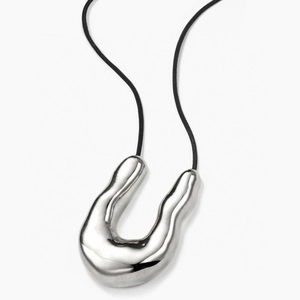Minimalist irregular U-shaped silver pendant with black cord on white background