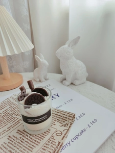 Detail of soy wax scented candle with realistic chocolate and cookie dessert toppings