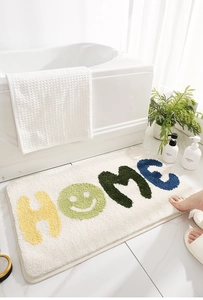 Dettaglio della scritta HOME su tappetino da bagno assorbente in microfibra antiscivolo