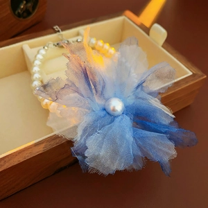 Detail of a blue mesh flower pearl bracelet inside a premium wooden jewelry box