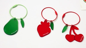 Detail of pear, strawberry, and cherry acrylic keychains with colorful wire rings