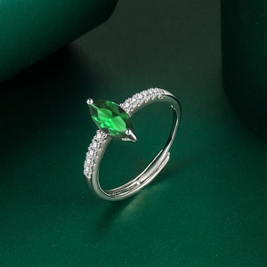 Macro shot of marquise-cut green gemstone ring with pavé side stones on adjustable band