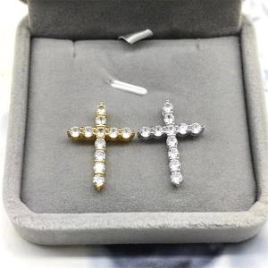 Detailed view of silver and gold cross pendants with sparkling cubic zirconia on velvet