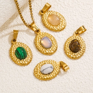 Gold oval pendant necklace with colorful turquoise stones on white textured background