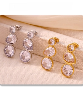 Macro shot of PVD gold and silver plated drop earrings featuring high-clarity zircon stones