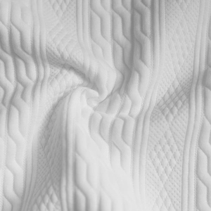 Makroaufnahme der weißen Strickstruktur mit Zopfmuster und Rauten-Details