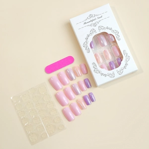 Detail of lavender press-on nails set with glitter accents and manicure tools