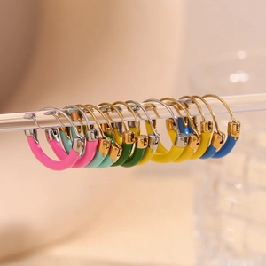 Macro detail of multicolored enamel hoops hanging on a transparent bar with 18K gold plating