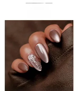 Detail of mocha brown cat eye press-on nails with 3D rose relief and almond shape