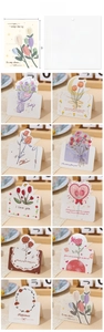 Close-up of 10 romantic floral 3D greeting cards with roses and tulips on white cardstock
