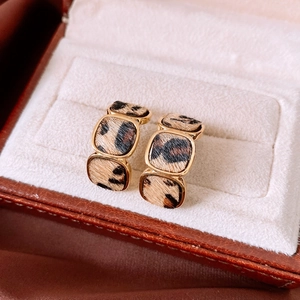 Close-up of geometric leopard print earrings with gold plating in a velvet jewelry box