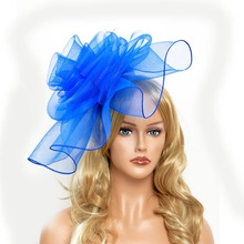 Detail of blue mesh bridal fascinator with soft feathers on a female mannequin