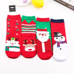 Flachbild von vier Paar Weihnachts-Baumwollsocken mit Rentier- und Weihnachtsmann-Motiven